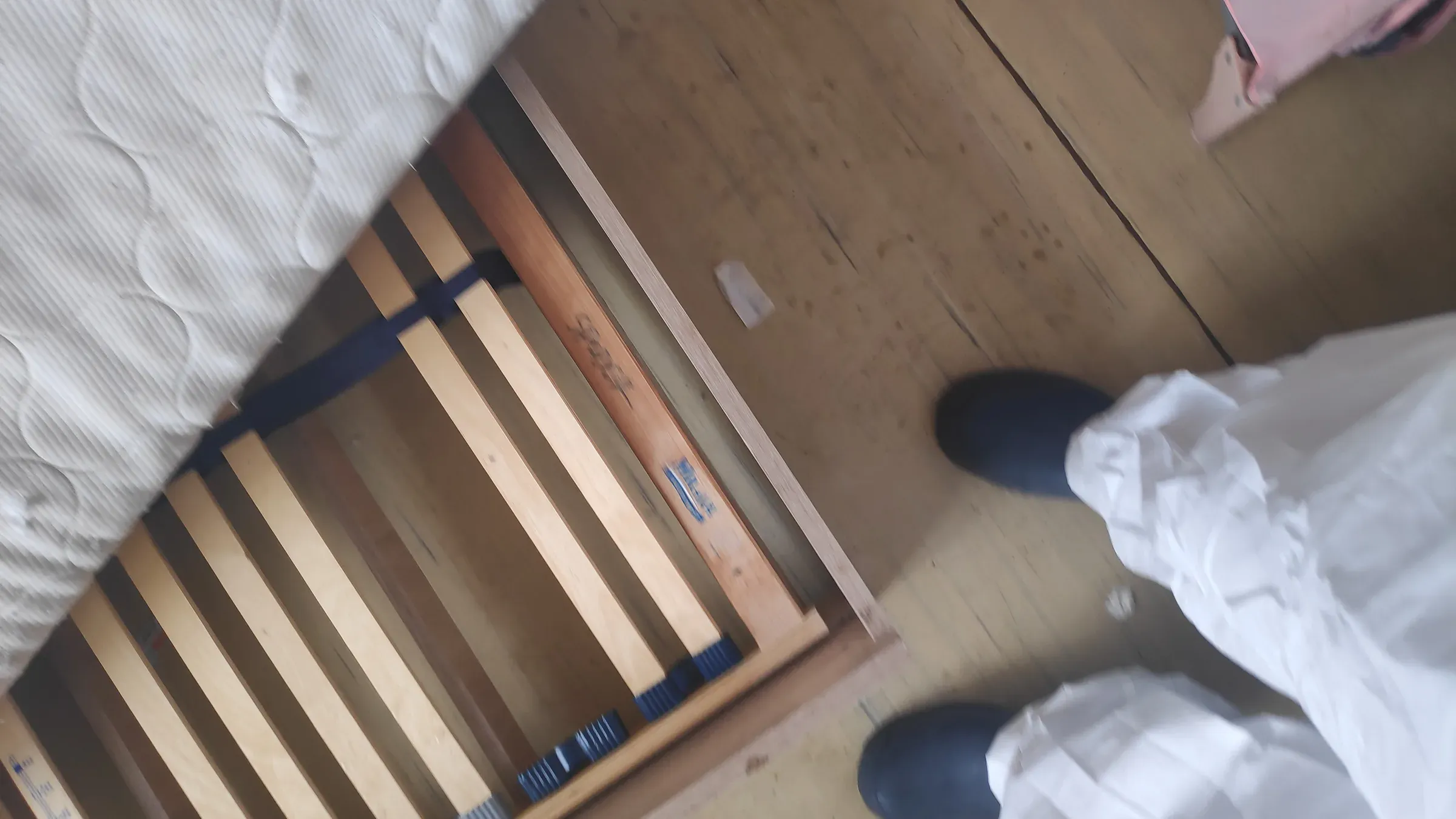 Technik v ochrannom odeve pri obhliadke rozobranej postele